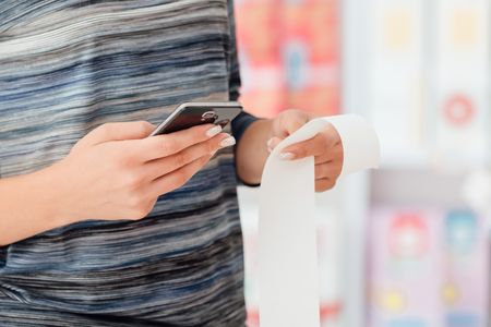 Business owner taking a photo of an expense receipt with their phone